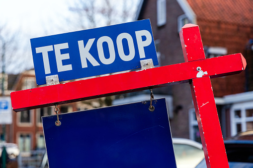 Sales board in a street with the text for sale in Dutch