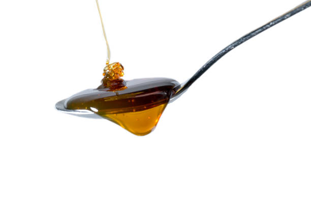 istock Honey flows onto a full teaspoon and begins to run off the spoon.isolated on white 2035552460