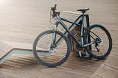 Mountain bike leaned against a wooden bench on a serene lakeside boardwalk at dusk.