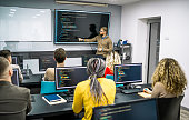 Male teacher instructs students in a programming school