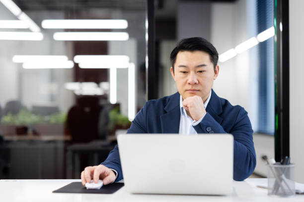 istock Focused businessman working on laptop in modern office space 2035617303