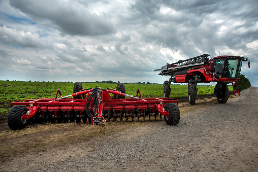 a new harrow cultivator, a self-propelled sprayer stands near a field of green beets, an exhibition of agricultural technologies, preparation for the season