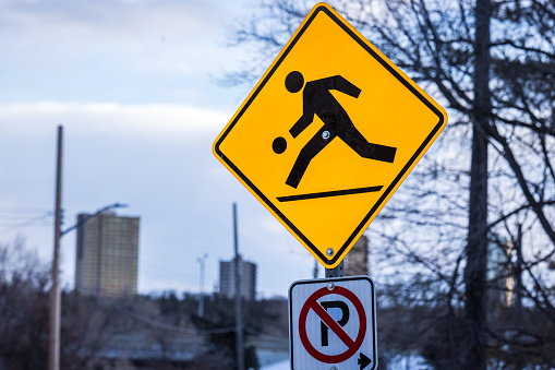 Edmonton, Canada – Yellow street sign with pedestrian with a ball