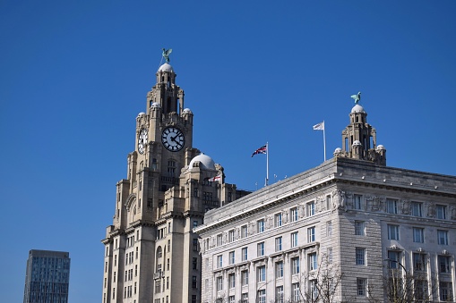 Liverpool, Merseyside, United Kingdom - April 18 2023: Liverpool's iconic grade 1 listed Royal Liver Building and grade 2* The Cunard Building, of the protected Three Graces, located at the Pier Head.