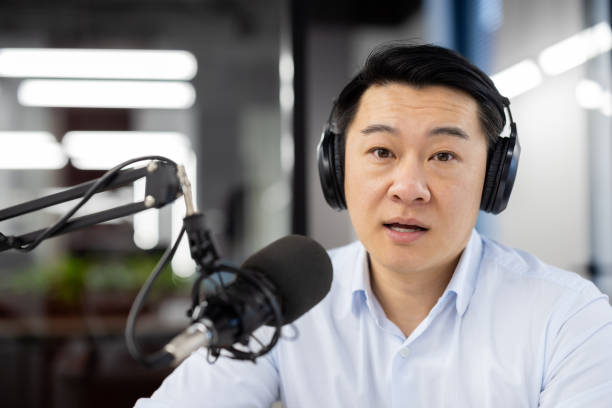 istock Professional asian male podcaster recording in studio with microphone 2035671373