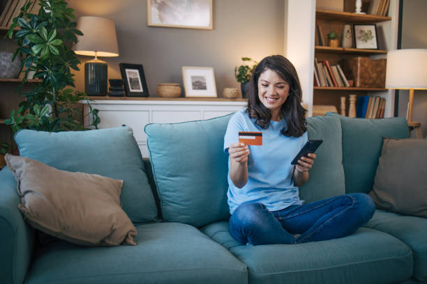 istock Beautiful woman using smart phone and credit card. 2035718535