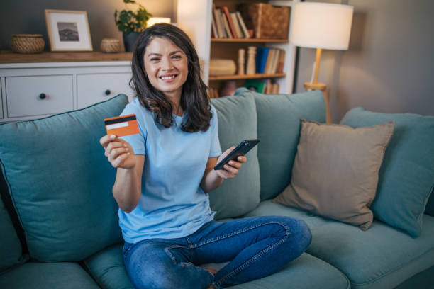 istock Beautiful woman using smart phone and credit card. 2035719016