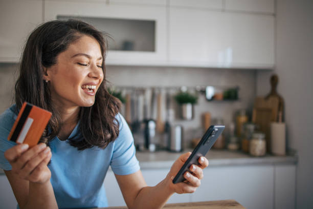 istock Beautiful woman using smart phone and credit card. 2035727977