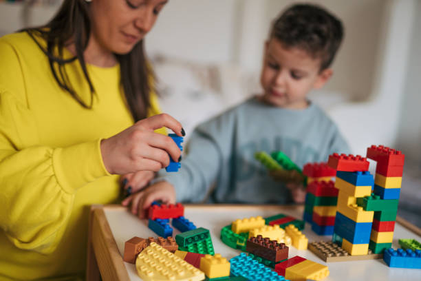A little boy spends time with his mother and plays with blocks.