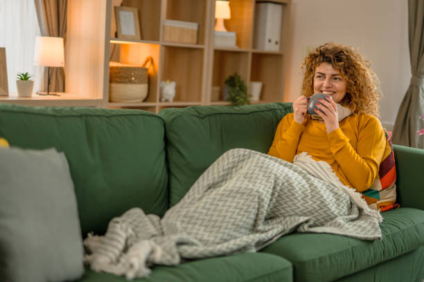 istock One woman is relaxing at home on the couch, drinking coffee or tea 2035737502