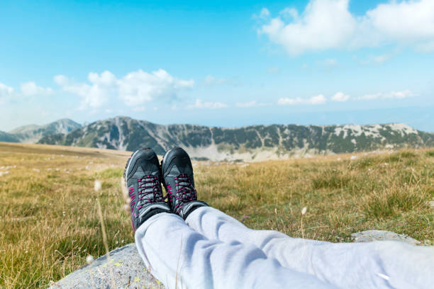 Personal perspective of woman  relaxing on top of Rila Mountain . Feet view . Travel vacations concept