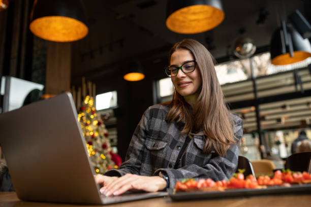 istock A freelancer concentrates on her laptop while having lunch at a restaurant. 2035755372