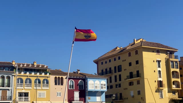 Spanish yacht ensign flag waving against blue sky