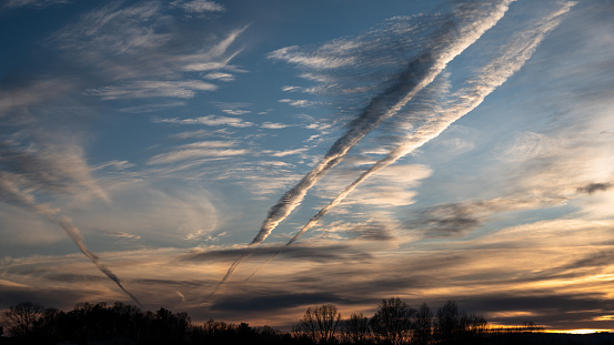 Contrails Reaching Across the Sunset Sky