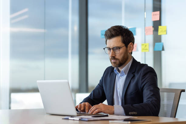 istock Focused businessman working on laptop in modern office space 2035814354