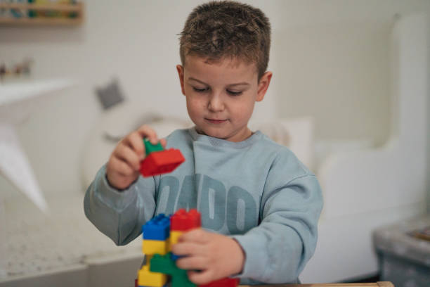 istock little boys building something with plastic blocks on the table. 2035847365