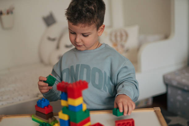 istock Close-up of little boys building something with plastic blocks on the table. 2035849967