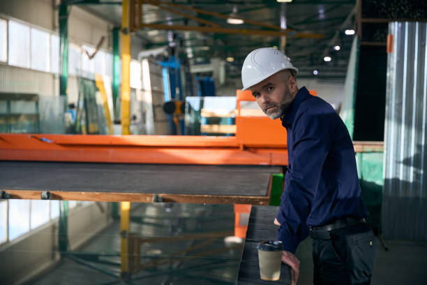 istock Foreman in safety helmet at workplace in window production facility 2035856751