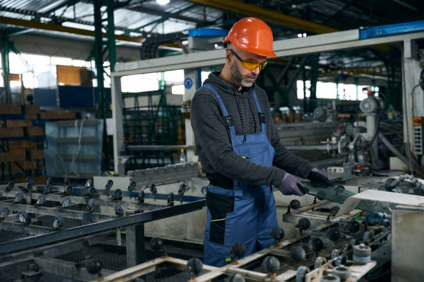 istock Middle-aged man processes the edge of glass using high-tech equipment 2035857199
