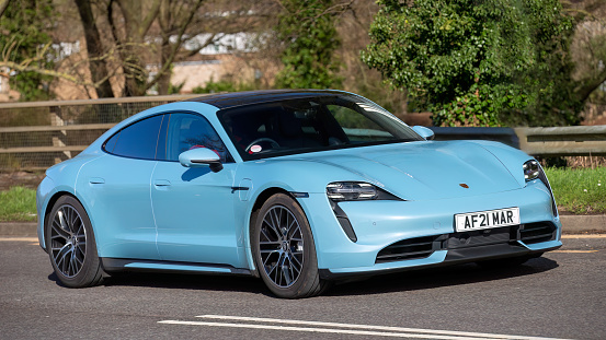 Milton Keynes,UK-Feb 24th 2024: 2021 blue Porsche Taycan Turbo electric car driving on an English road