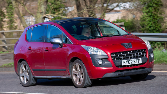 Milton Keynes,UK-Feb 24th 2024: 2012 red Peugeot 3008 diesel engine#  car driving on an English road