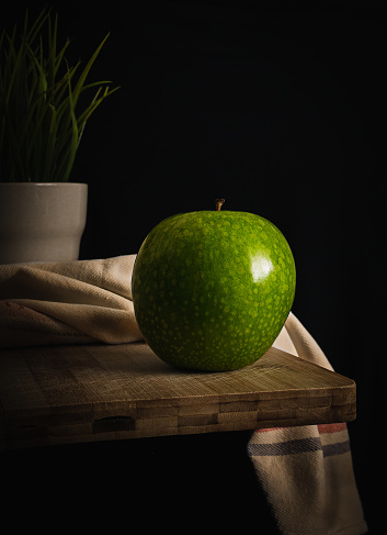 beautiful still life photograph of a green apple with a very characteristic green spotted skin