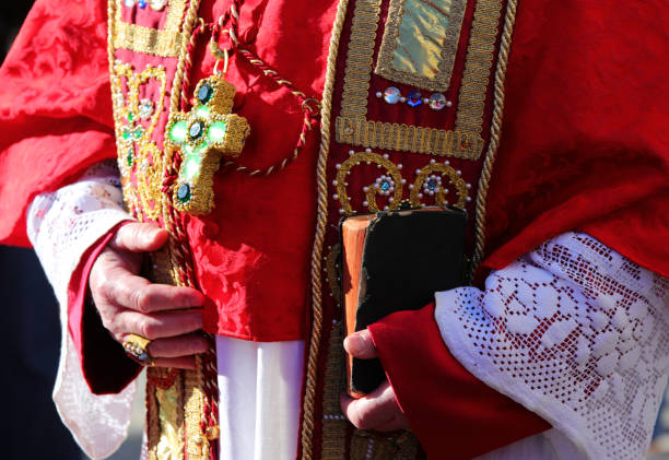 istock priest with red robe holding bible in hand during religious ceremony 2035875293
