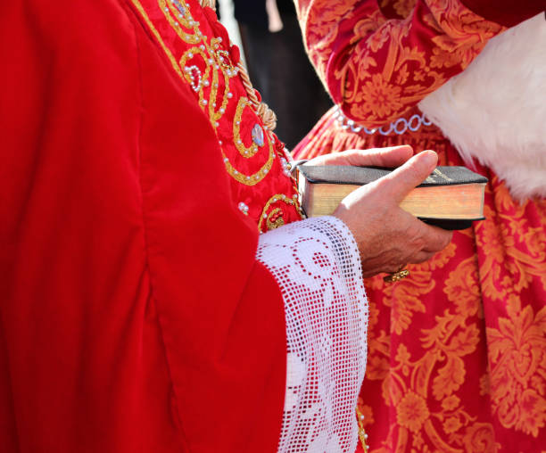 istock elderly bishop with red cassock and the ancient bible with the sacred scriptures in his hand during the religious rite 2035876894
