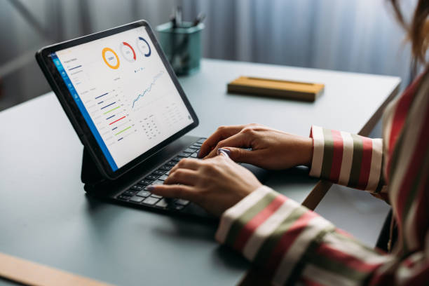 istock Businesswoman Analyzing Financial Graphs on Tablet at Workplace 2035914545