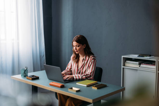 istock Professional Woman Working on Laptop in a Modern Office Setting 2035914550