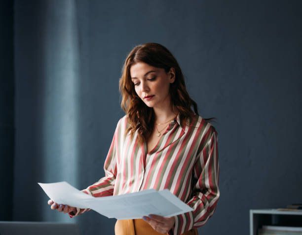 Professional Woman Reviewing Documents in Stylish Office Attire