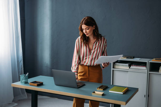 istock Professional Woman Reviewing Documents at Modern Office Desk 2035914839