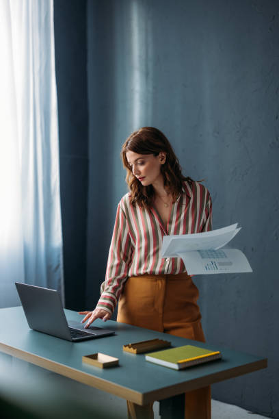 istock Professional Woman Reviewing Documents at Modern Office Desk 2035915084