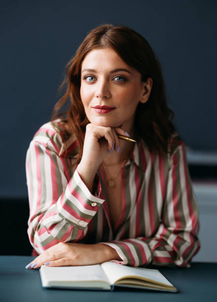istock Confident Businesswoman Posing with Pen and Notebook in Office Setting 2035915624