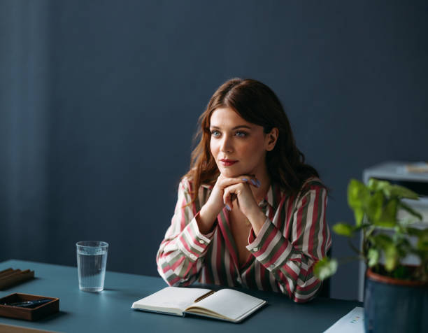 istock Thoughtful Businesswoman with Notebook in Modern Office Setting 2035915640