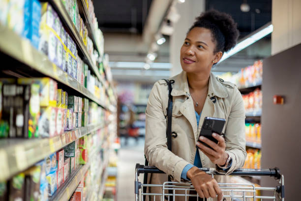 Female Customer Checking Shopping List on Her Smartphone at Supermarket