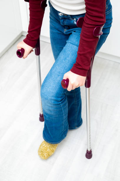 A young girl is on crutches in the hospital