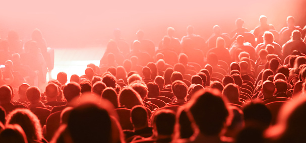 many heads of people during live concert and red lights