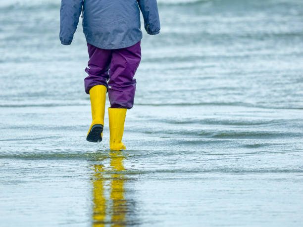 Girl walking in the tide along the shoreline of Pacific Rim National Park on Vancouver Island, British Columbia