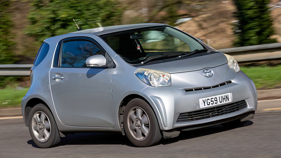 Milton Keynes,UK-Feb 24th 2024: 2009 silver Toyota IQ car driving on an English road