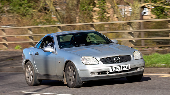 Milton Keynes,UK-Feb 24th 2024: 1999 silver Mercedes Benz SLK car driving on an English road