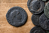 Ancient Roman coin with portrait of emperor Maximinus, old worn bronze money on close-up on vintage background. Concept of Rome, Empire, texture, collection, artifact, civilization