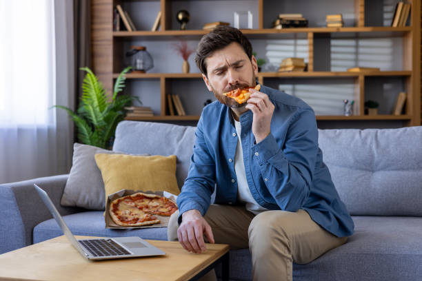 istock Casual businessman enjoying pizza during break at home office space 2036017893