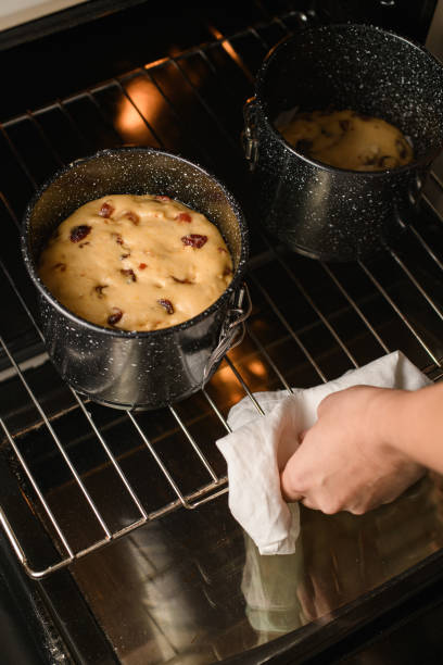 Baker takes out Easter cakes in metal forms from the oven