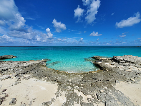 Crystal clear water amidst rocks and sandy beaches of North Bimini's west coast in Bahamas.