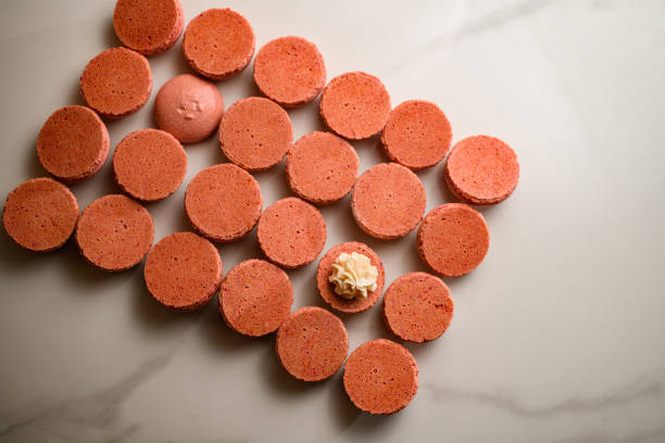 istock Pink half blanks for the French macaroon dessert on a white table 2036132777