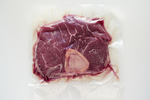 Organic beef (Osso buco ) in a vacuum sealed package with white background