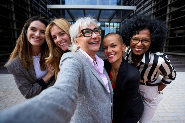 istock Group diverse business formal women taking selfie with mobile phone looking smiling at camera. 2036310061