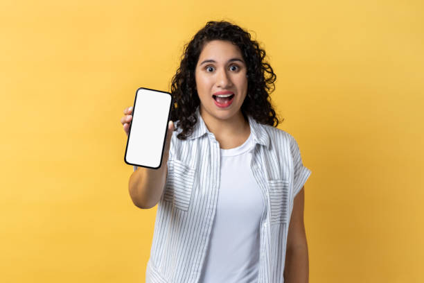 istock Woman holding phone with empty display, advertisement area, copy space for promotional text. 2036398298