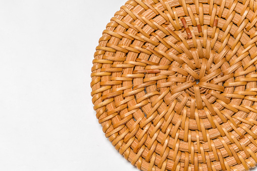 Wicker tray on white background. Rattan weave circles. Beautiful brown rattan pattern background.